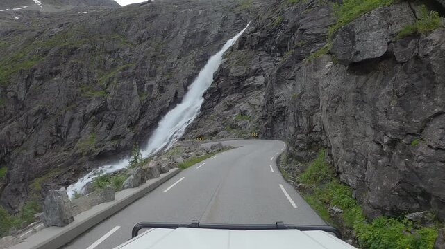 POV of vehicle driving down Trollstigen, a narrow road through mountain landscape of Norway