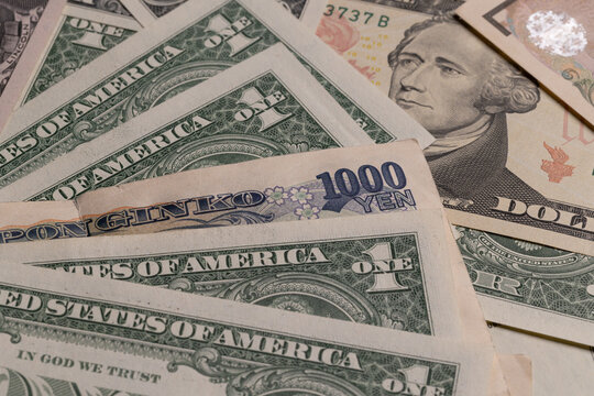 Japanese yen banknotes mixed with US dollar bills currency background