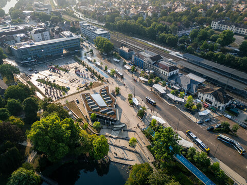 Aerial view of Tubingen Hauptbahnhof with its modern station building, green roof, bus terminal, railway tracks, and surrounding urban landscape in Tubingen, Baden-Wurttemberg, Germany.