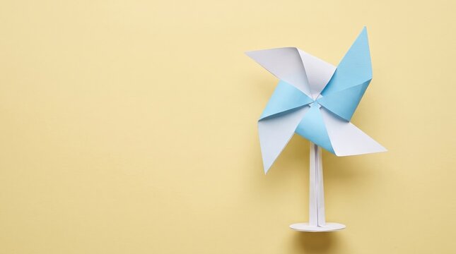 Colorful Paper Pinwheel Toy on Soft Yellow Background Perfect for Children's Themes and Designs