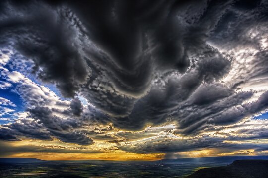 Storm clouds rolling over sunset plain with distant horizon
