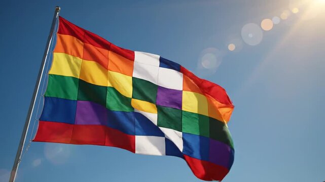 Waving Rainbow Wiphala Flag Against Bright Sky with Sun Flares