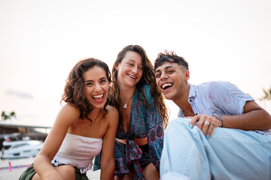 Friends enjoying a fun travel adventure on a tropical beach at sunset, making lasting memories