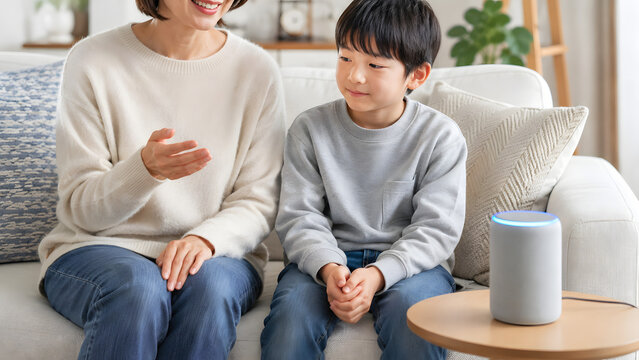 リビングのソファでスマートスピーカーに向かって話しかける母親と息子
