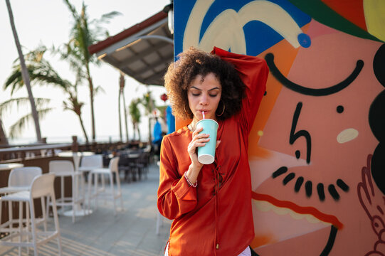 Successful woman embracing a feeling of liberation, standing confidently against vibrant street art