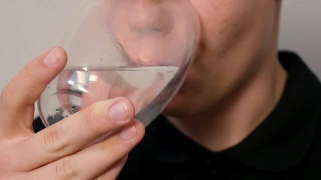 Close-Up of a Young Man Drinking Fresh Pure Water from a Double-Walled Glass