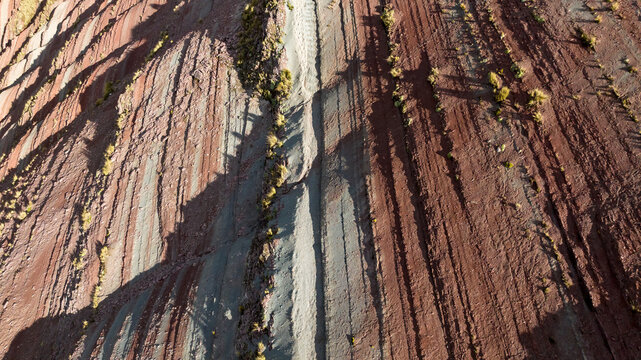 Aerial view of the colorful mineral-rich sedimentary rock layers of Vinicunca, or Rainbow Mountain, with rugged terrain in Quispicanchi Province, Cusco, Peru.