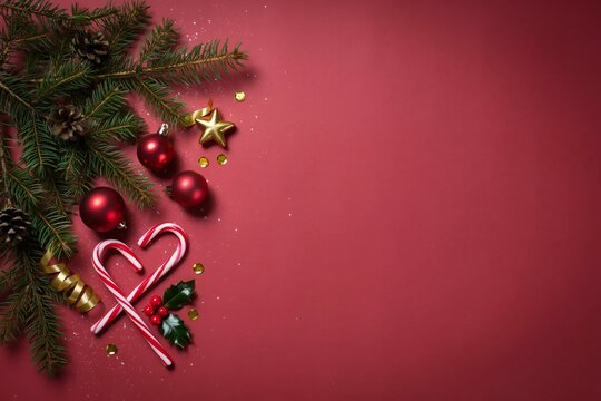 christmas festive corner with fir branches candy canes ornaments on red holiday background with copy space