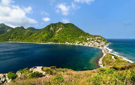 A scenic high angle view of the isthmus and bay at Scotts Head in Dominica, showing the Caribbean Sea and Atlantic Ocean.
