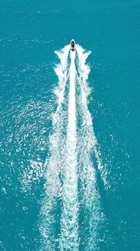 Speedboat crossing turquoise sea leaving white foam wake
