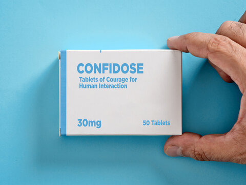 Hand holding confidode tablets of courage for human interaction