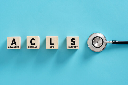 Advanced cardiac life support acronym on wooden cubes and stethoscope on blue background