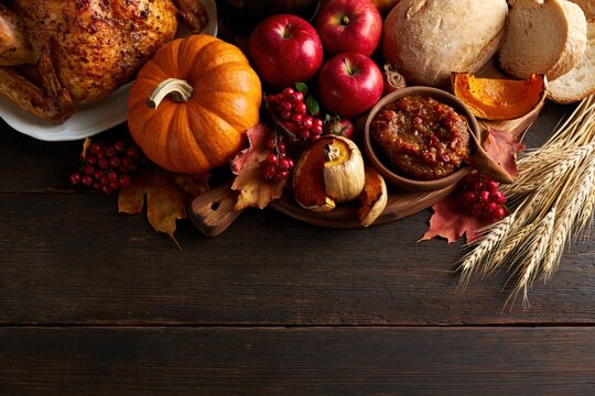 Thanksgiving Rustic Flat Lay with Roasted Turkey Pumpkin Apples Wheat and Copy Space on Dark Wooden Background