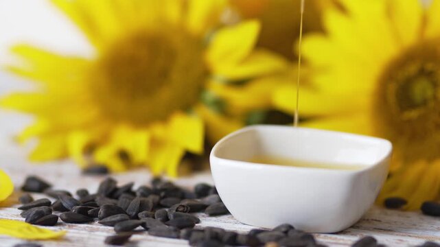 Pouring healthy vegetable sunflower oil into white ceramic cup clip