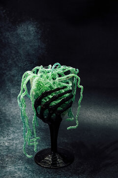 Halloween treat in a black cup with green candy and a spooky design for a festive celebration
