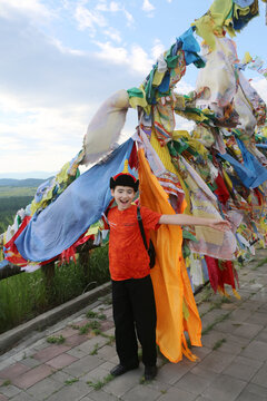 Historical monument Datsan Rinpoche Bagsha on Bald Mountain, buddist temple, landmark, sight. Tourist child, kid, cute boy in Buryat traditional national costume, hat. Buryat architecture in Ulan-Ude 