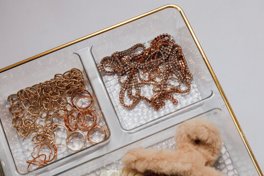 Jewelry and trinkets displayed in a clear tray on a flat surface