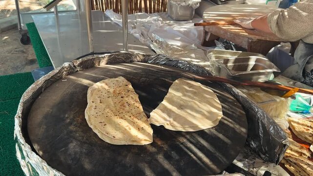 Traditional Turkish g&ouml;zleme being cooked on a saj griddle by a street food vendor. Fresh handmade flatbread baked with savory filling using authentic cooking techniques. High quality 4k footage