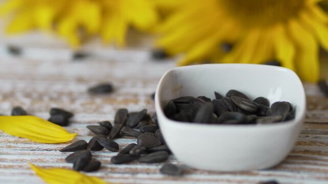 Closer view of sunflower seeds in white bowl with kitchen spoon video