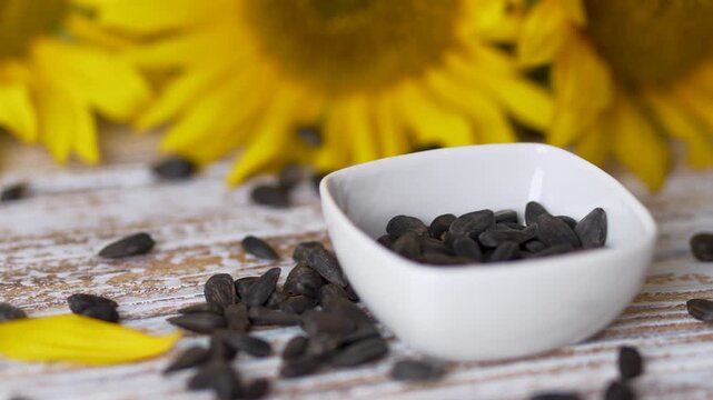 Closer view of sunflower seeds in white bowl with kitchen spoon video