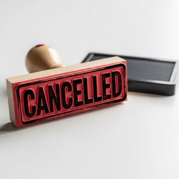 A wooden rubber stamp with the word CANCELLED carved on its face