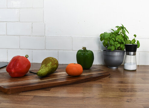 Fresh Vegetables and Fruit on a Chopping Board on a Kitchen Counter