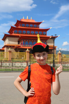 Historical monument Ivolginsky datsan "Khambyn Khuree", buddist temple, landmark, sight. Tourist child, kid, cute boy in Buryat traditional national costume, hat