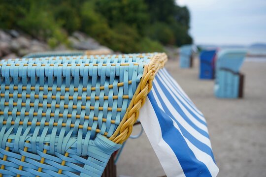 Detailansicht eines blau-gelben Strandkorbs mit gestreiftem Stoff am Strand von Sierksdorf an der Ostsee in der L&uuml;becker Bucht