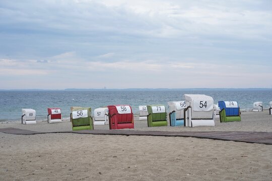 Bunte Strandk&ouml;rbe am Ostseestrand von Sierksdorf unter bew&ouml;lktem Himmel in der L&uuml;becker Bucht