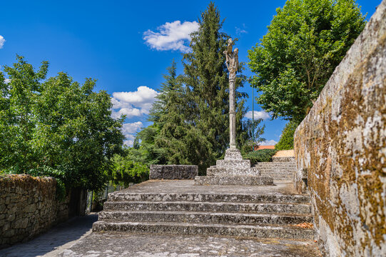 Stone cruzeiro cross standing at top of steps on a sunny day