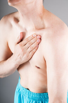 Close up of man touching aching collarbone, clavicle pain or shoulder joint injury concept