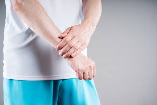 Unrecognizable man massaging pain wrist. Concept treatment sports injury, arthritis, gout and inflammation wrist joint in medicine