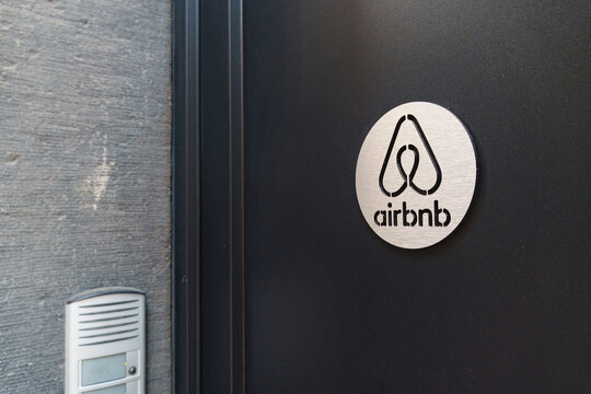 Liege, Belgium - June 16 2026: Airbnb logo plaque mounted on a black door with clean minimalist branding design