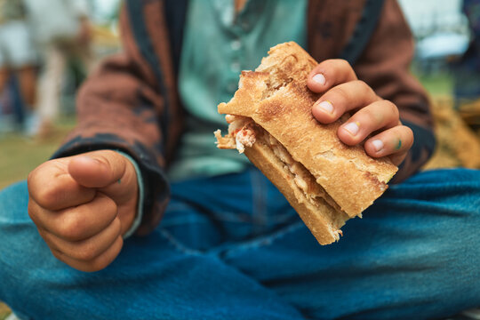 Child's hands holding a chicken ciabatta sandwich at a festival