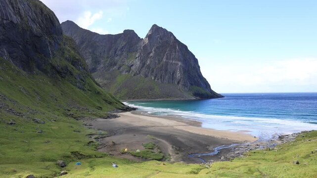 View of Kvalvika Beach in Lofoten, steeply rising mountain landscape above ocean in Norway