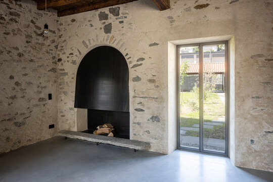 Detail of a French window. Interior of a room with a fireplace and a window; no people inside.