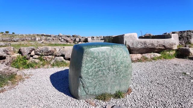 The famous smooth green nephrite stone block stands amid the ancient ruins of the Great Temple at Hattusa, Turkey.