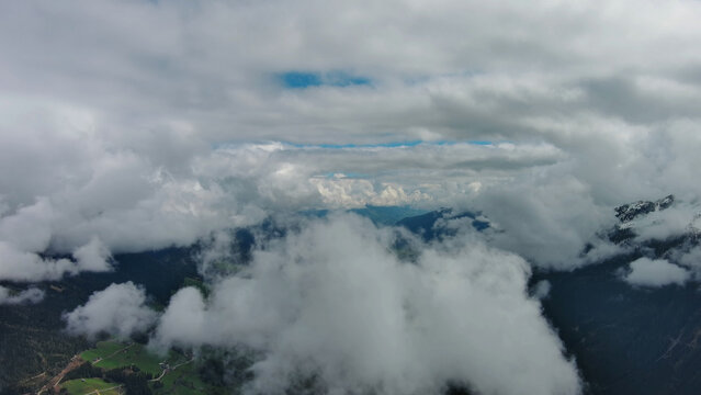 Aerial view of snowcapped mountains in clouds