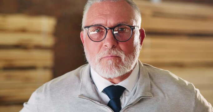 Face, serious or mature man in carpentry for woodworking industry, occupational pride or expertise. Glasses, workshop manager and adjust clothes for carpenter discipline, trade confidence or about us
