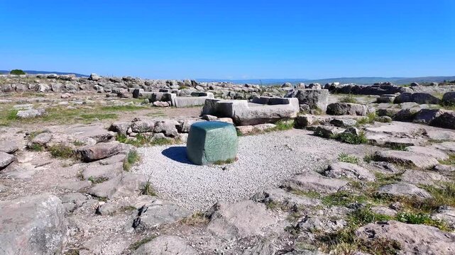 The famous smooth green nephrite stone block stands amid the ancient ruins of the Great Temple at Hattusa, Turkey.
