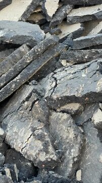 Pile of broken asphalt pieces creating a textured background suitable for construction themes