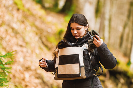 Young woman hiking carrying black cat in valley