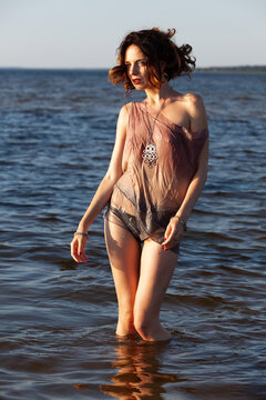 Woman wearing sheer clothing standing in water