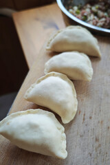 Fototapeta premium Hand-made dumplings with stuffing, a traditional Russian dish