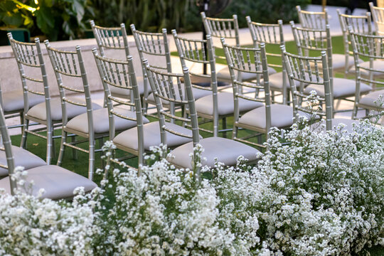 Elegant Outdoor Wedding Ceremony Setup with Silver Chiavari Chairs and White Floral Decor