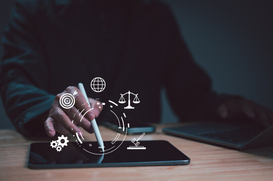 Lawyer holding stylus touching tablet screen showing legal icons' consultation contract strategy business management enterprise planning industry sector law justice court policy regulation compliance.