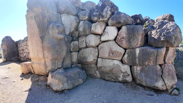 Massive cyclopean stone masonry wall section built with fitted ancient boulders at the Hattusa archaeological site in Turkey.