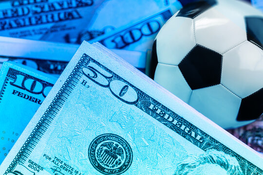 Sport betting with cash and a soccer ball placed together on a table for a betting activity