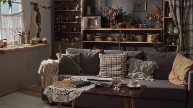 Empty rustic living room interior showing home interior setup with book, glasses, and tea cup on table. Footage is ideal for real estate marketing or home decor advertisements