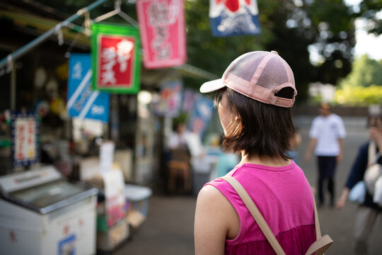 夏祭りの屋台を見つめる女の子の後ろ姿